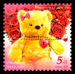a female teddy bear with a bouquet of red roses and a heart in the form of a lock