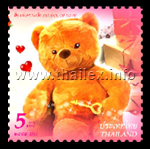 a male teddy bear with a box of gifts in the background and holding a key with a heart-shaped handle, which represents the key to the heart